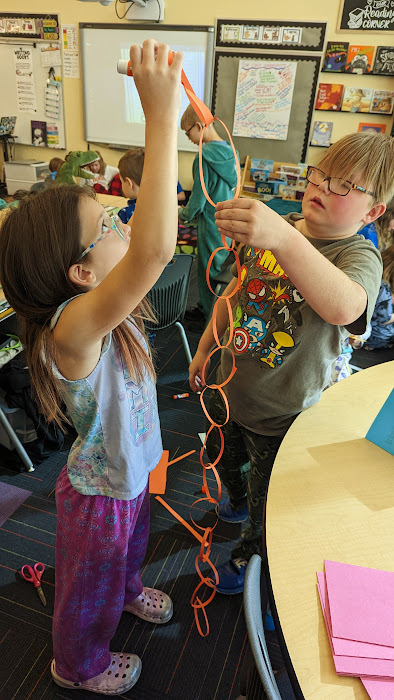 4th graders hold their chain up